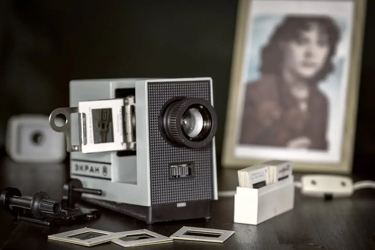 Close-up of a retro slide projector with blurred photo frame in the background.